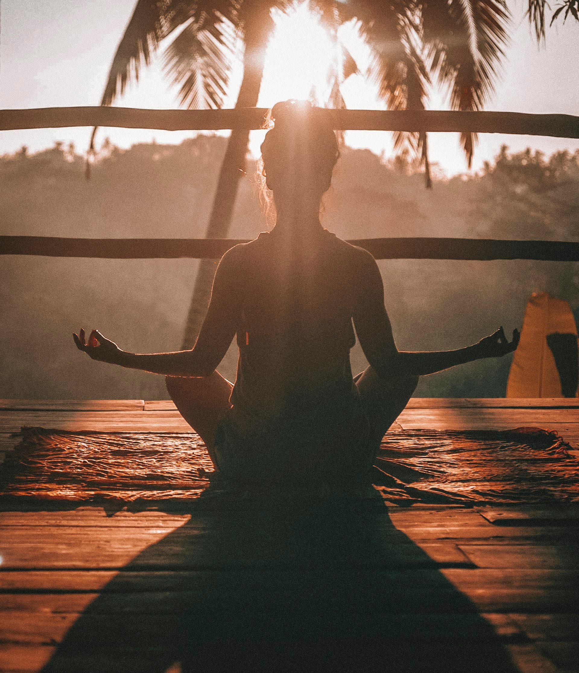 Woman doing yoga stretches outdoors in a park at sunrise